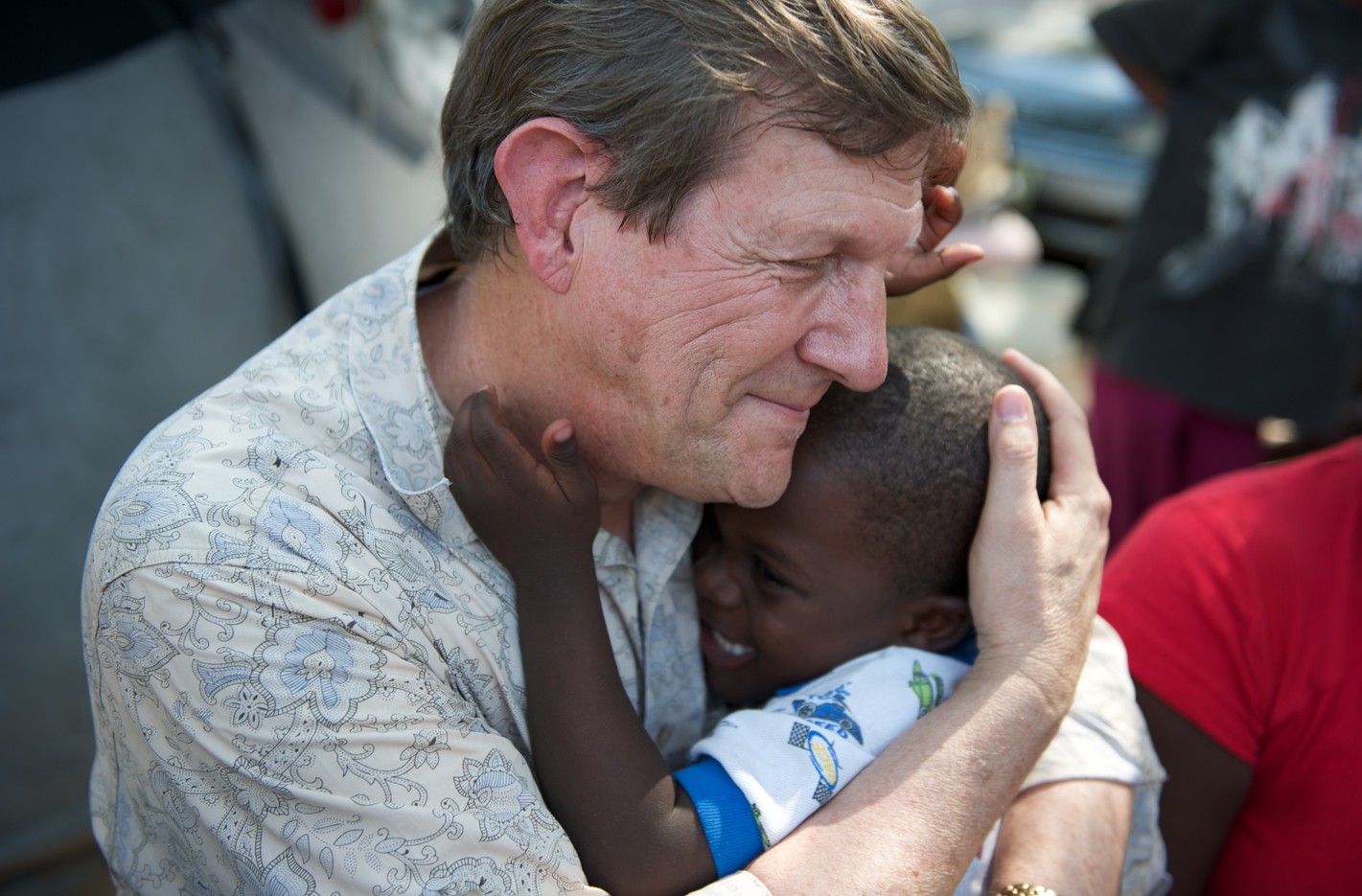 Wess Stafford embracing a child in his ministry work